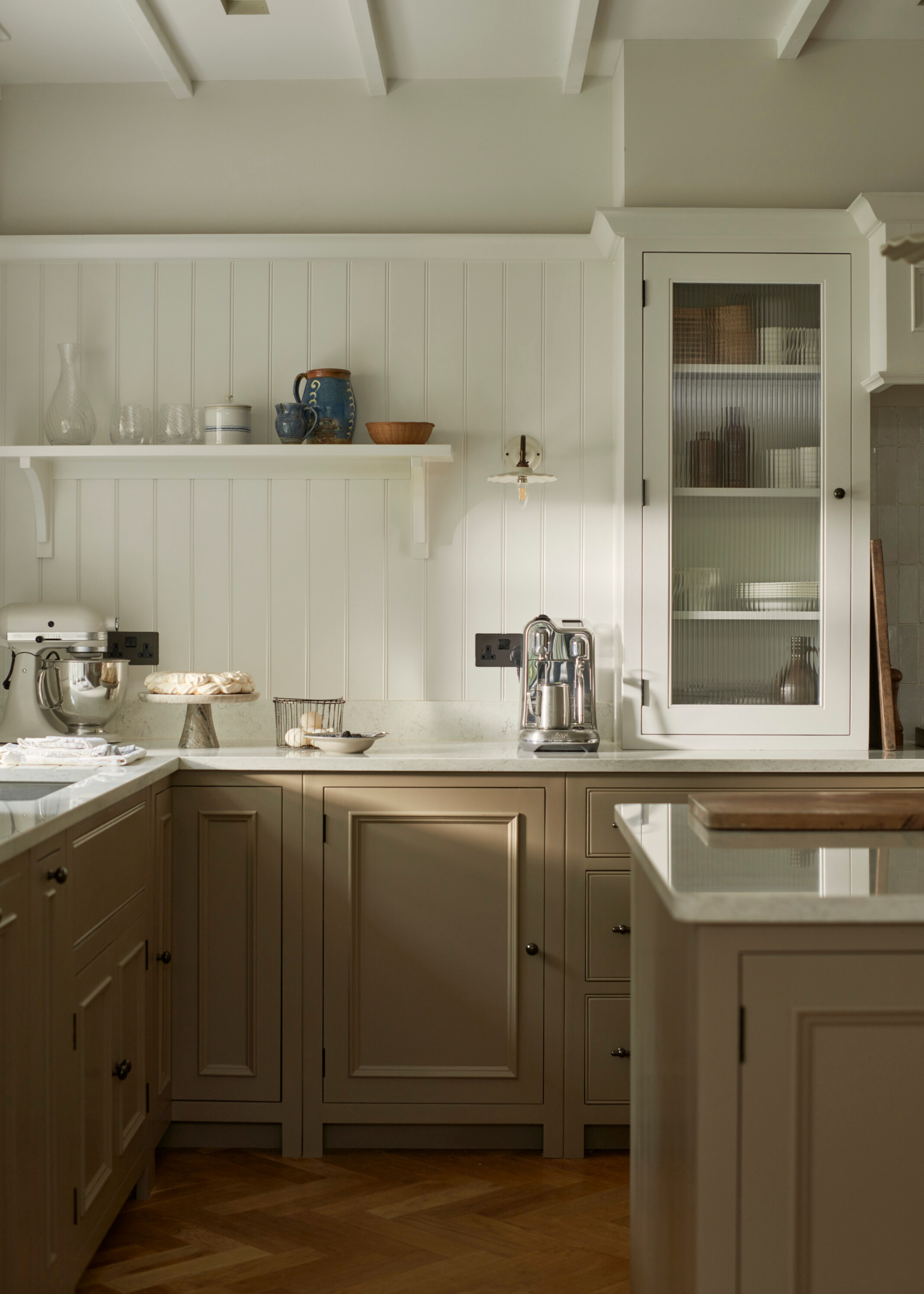A putty colour traditional kitchen with tongue and groove panelling around the wall