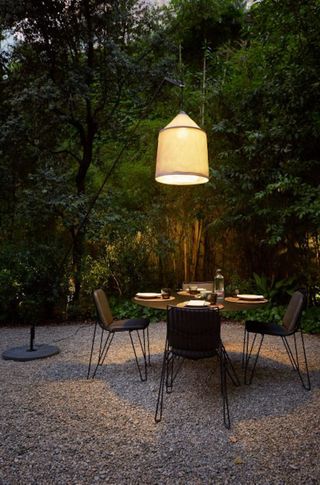 a garden lighting idea with a pendant light over a dining table