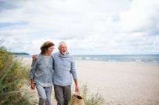 Happy couple strolling on the beach 