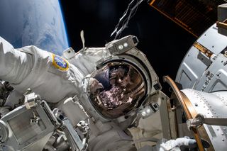 astronaut in a spacesuit floating in space with earth in behind