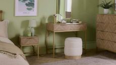 A fresh, modern, light green bedroom with rattan furniture from VonHaus.