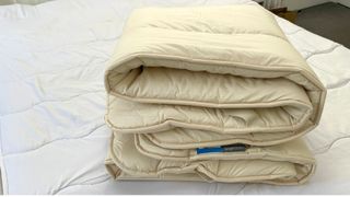 Woolroom mattress topper folded on top of mattress