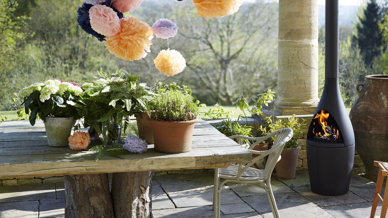 outdoor dining area with a modern woodburning fireplace