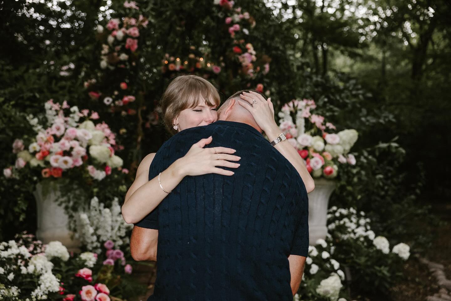Travis Kelce and Taylor Swift hugging in front of flowers