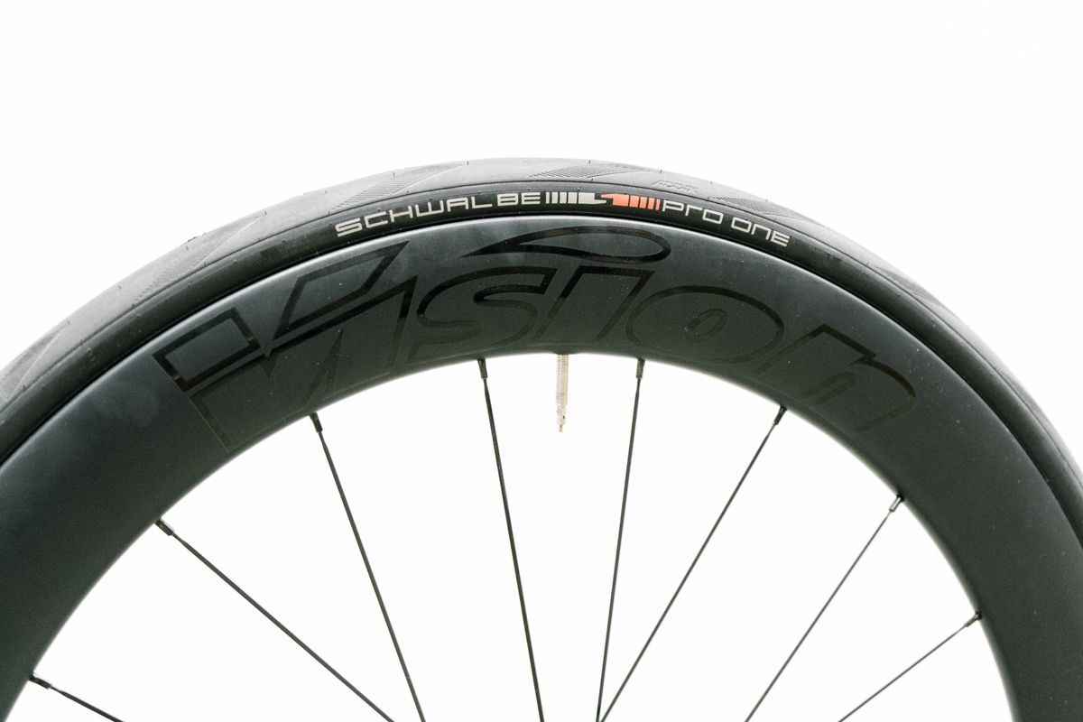 An aero road wheel stands against a white wall