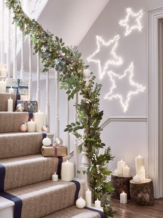 Christmas stair decor with garland and faux candles by Lights4fun