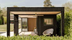 black timber clad garden room with veranda seating area