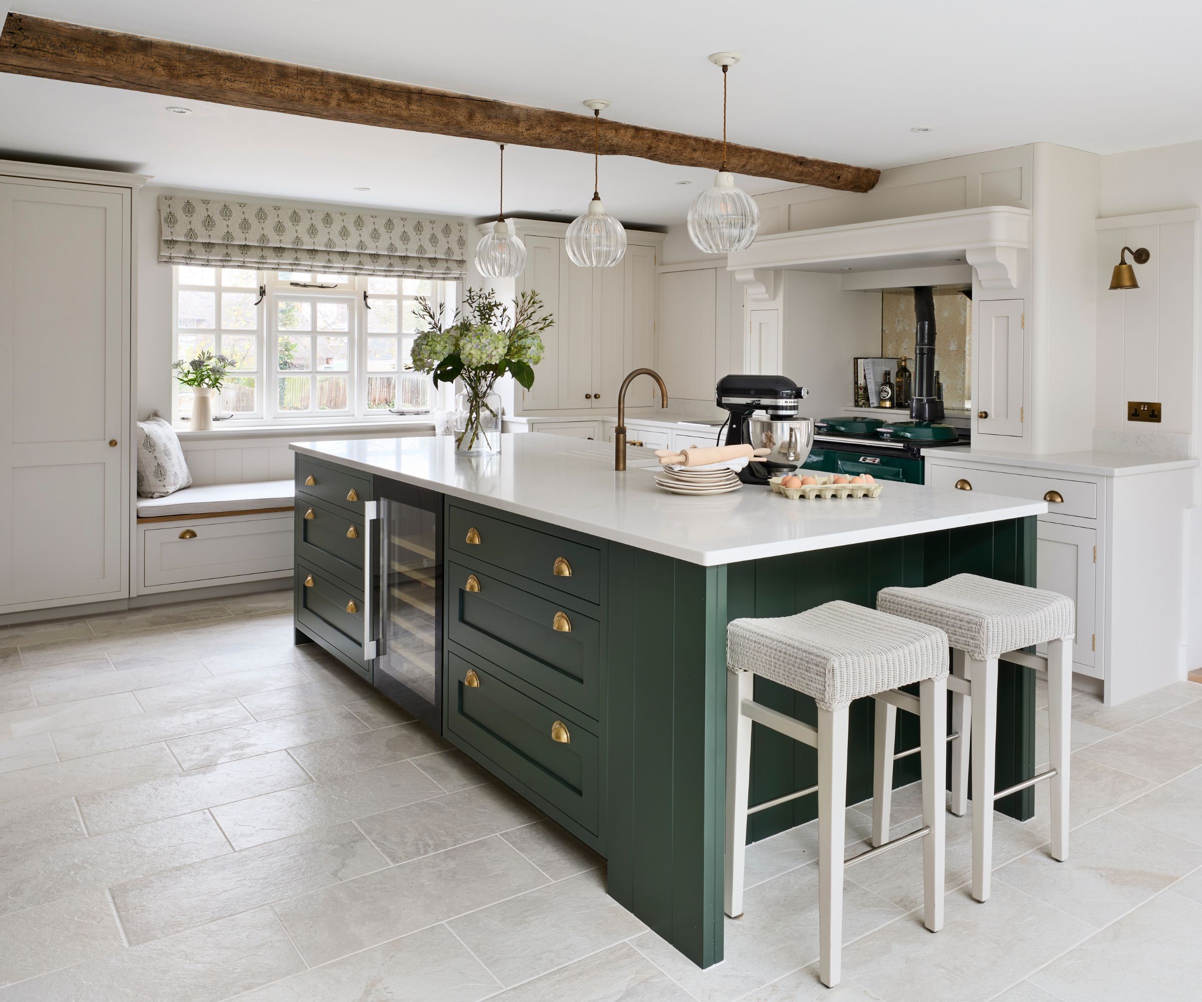 A luxury kitchen with white cabinets and a deep green island