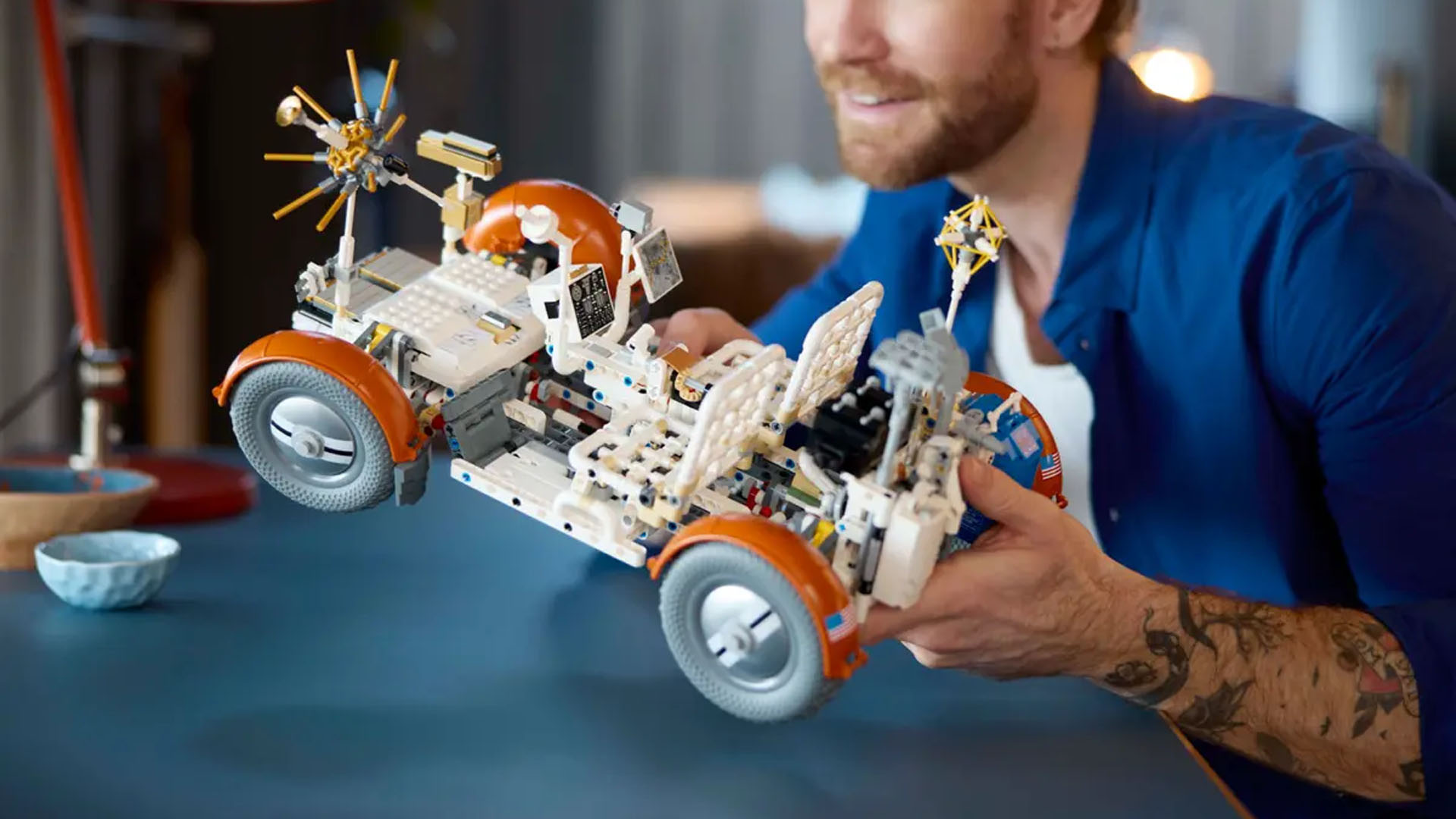 A person holding a LEGO Technic NASA Apollo Lunar Roving Vehicle