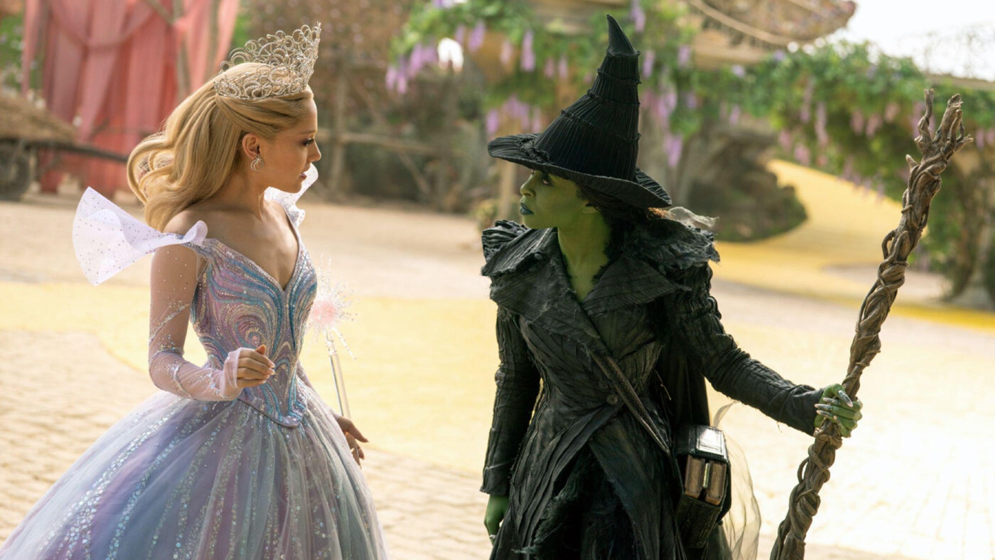Still from upcoming film 'Wicked: for good' featuring Ariana Grande as Glinde on the left and Cynthia Erivo as Elphaba on the right, both looking inward towards eachother