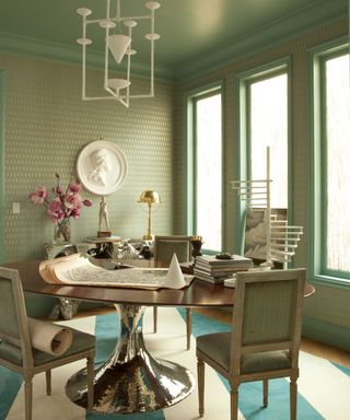 dining room with green wallpaper and pedestal table