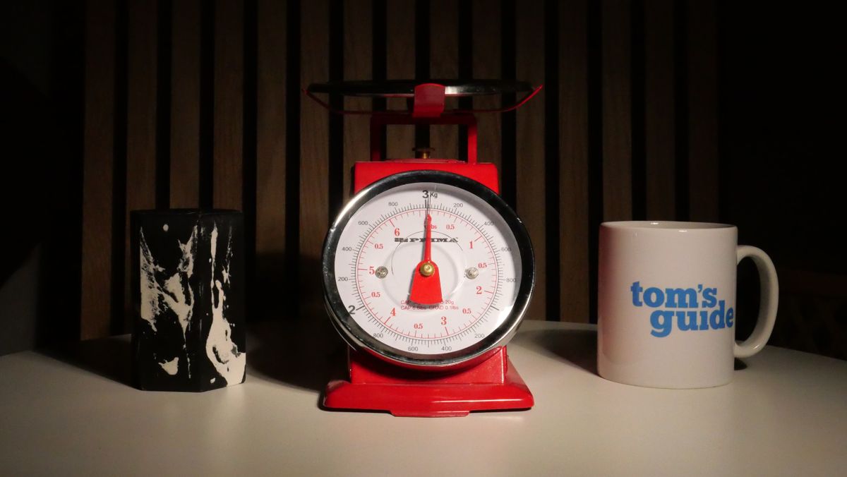A photo of a set of red scales next to a Tom's Guide Mug.