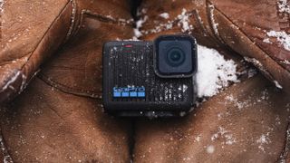 GoPro HERO action camera held in a pair of gloves