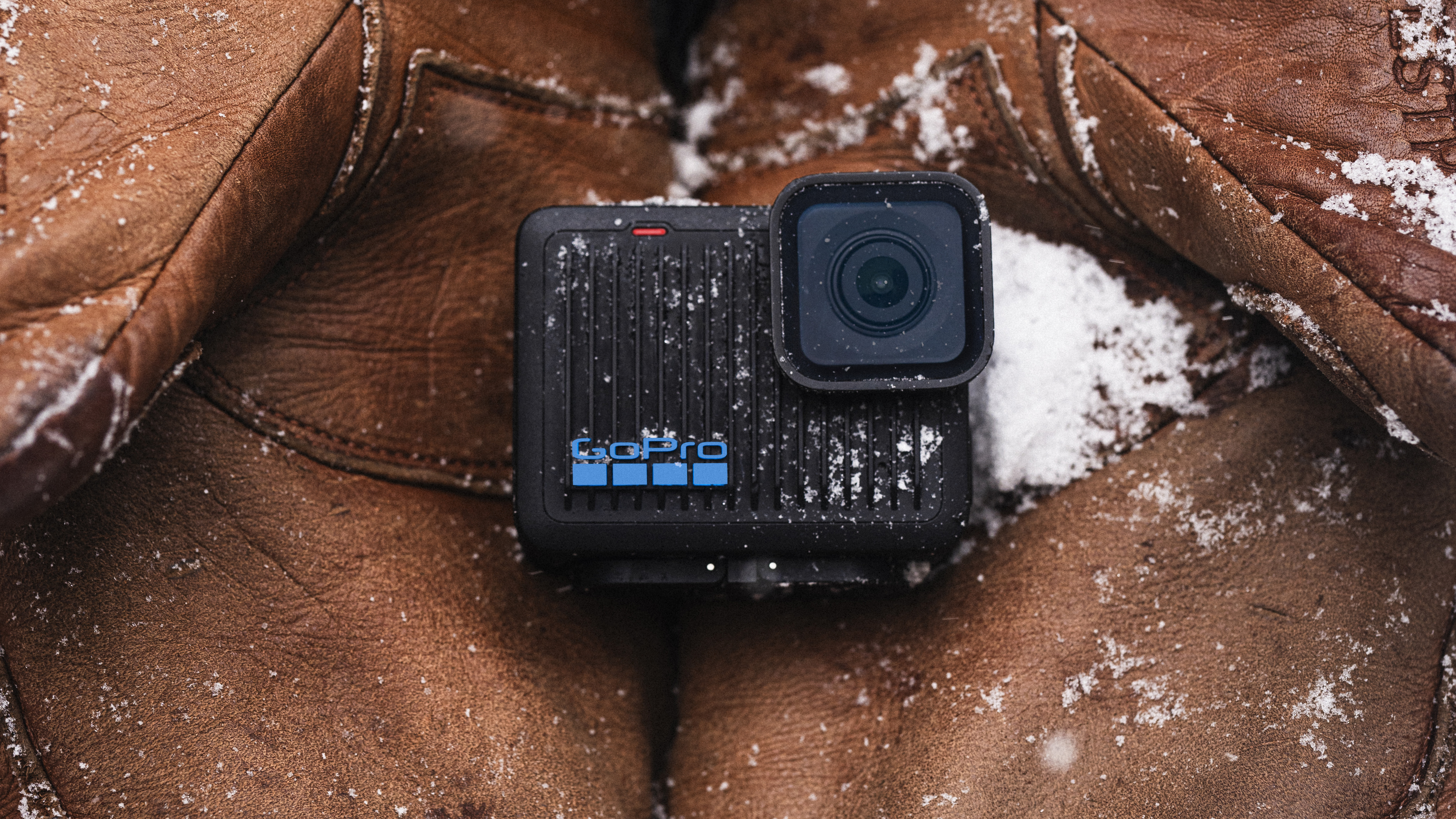 GoPro HERO action camera held in a pair of gloves