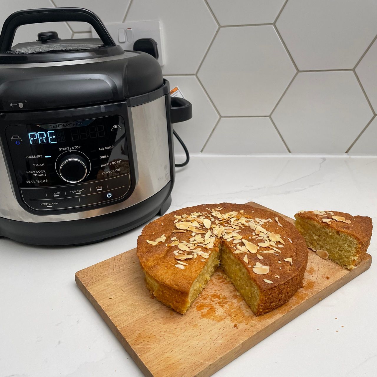 Ninja Foodi 9-in-1 Multi-Cooker with baked cake on a wooden cutting board