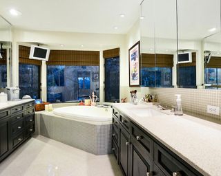 bathroom with bathtub black cabinet and mirror on wall