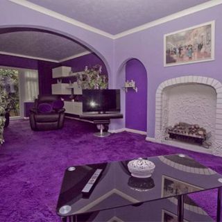 living room with purple wall and purple carpet floor with glass table