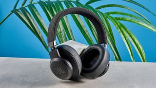 the jbl live 770nc headphones with a 3.5mm headphone jack, touch controls, usb-c port, and cushioned cups photographed against a blue tom's guide background