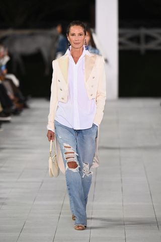 Christy Turlington walks the runway at Ralph Lauren's spring/summer 2025 runway show at new york fashion week wearing an ivory blazer and jeans