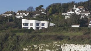 white rendered self build on edge of cliff