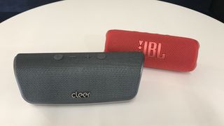 Cleer Scene next to JBL Flip 6, on a table