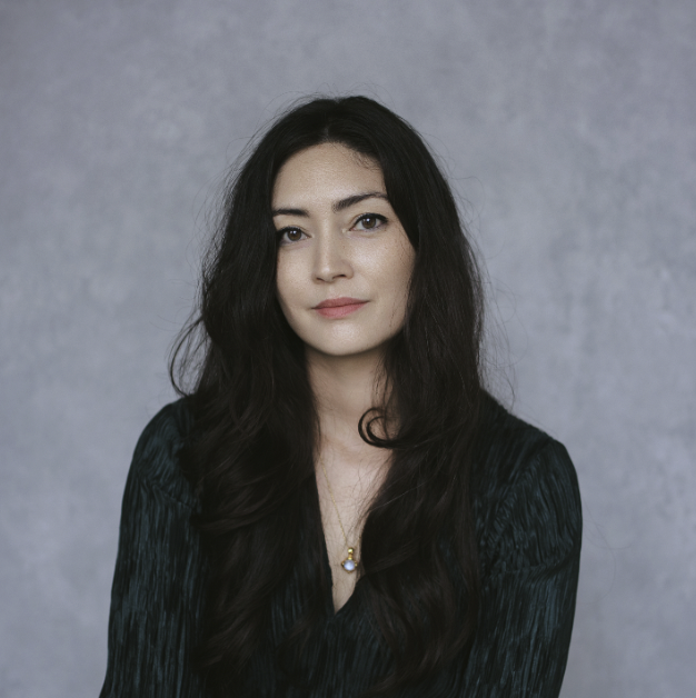 A headshot of a woman with long dark hair