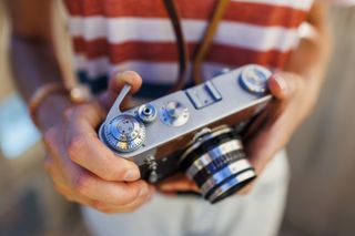 Close up of an analog camera in the hand, sunny weather