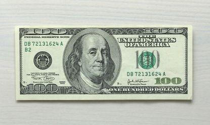 One hundred dollar bill note on white wood grain background