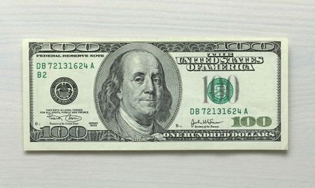 One hundred dollar bill note on white wood grain background