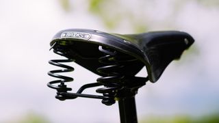 A close up of the rear of a black sprung saddle