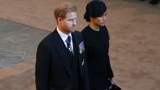 Prince Harry, Duke of Sussex and Meghan, Duchess of Sussex attend as the coffin of Queen Elizabeth II is escorted into Westminster Hall for the Lying-in State on September 14, 2022 in London, England.