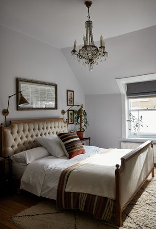Bedroom with chandelier, french bed and framed sheet music