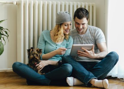 Man and woman smiling while using a tablet