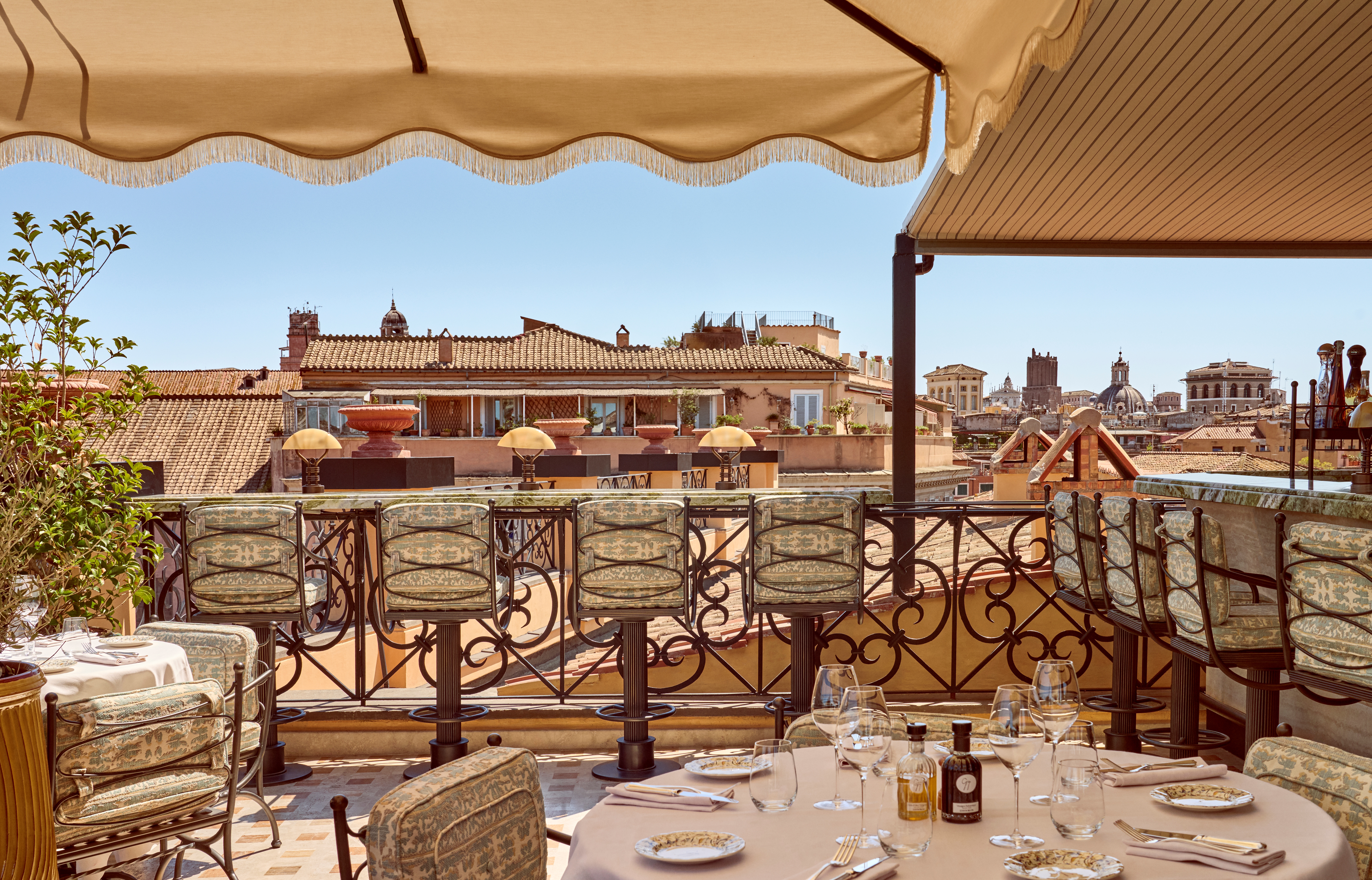 The interiors of a palatial hotel housed inside a 16th-century building with frescoed walls, textural arches, mesmerizing flooring, and plenty of wood oozes antique-inspired furniture and a golden atmosphere across sculptural furnishings, artworks, and plants.