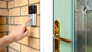 Person pressing video doorbell