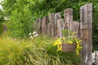 garden sleepers as fence with hanging basket