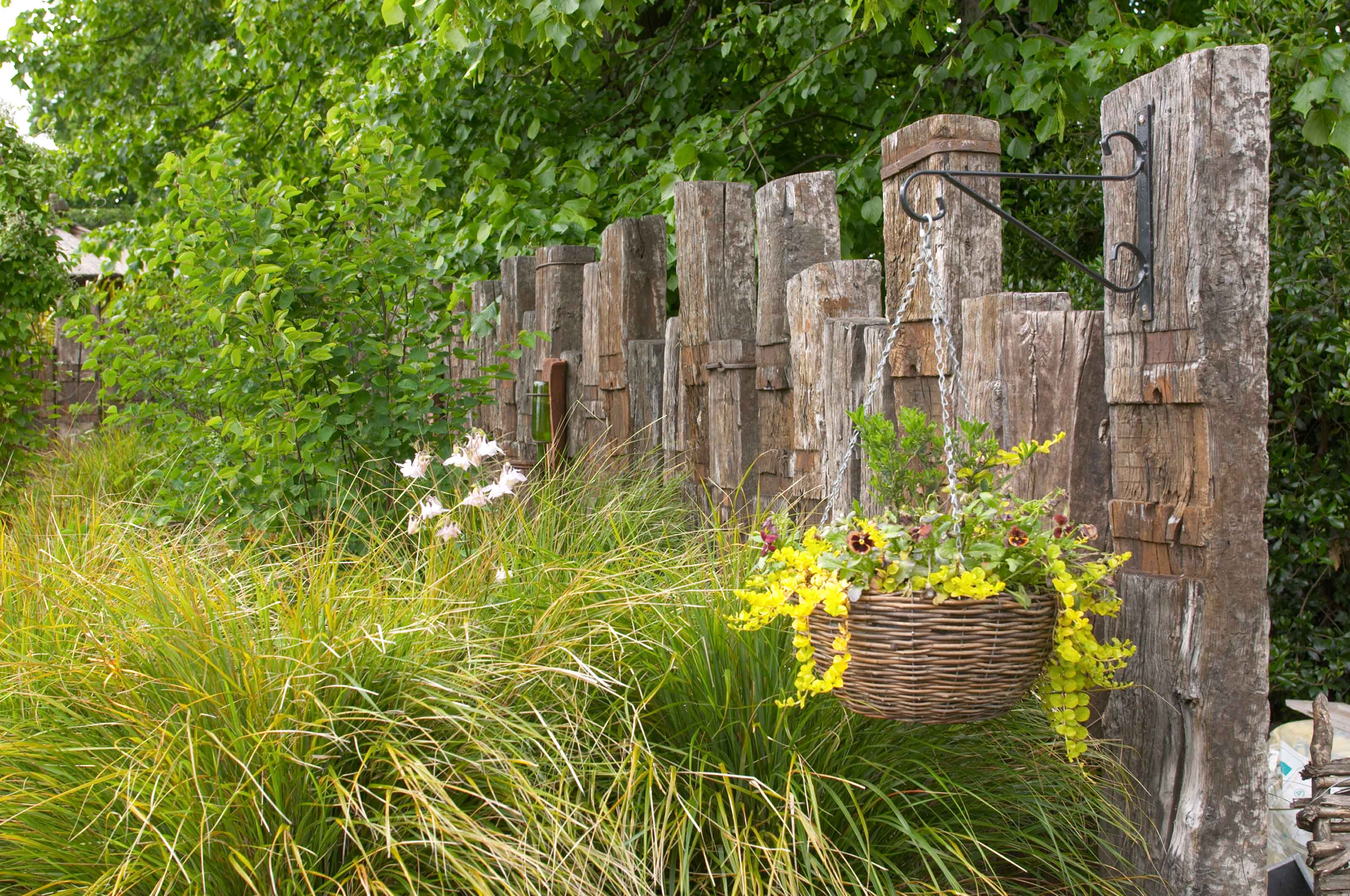 garden sleepers as fence with hanging basket