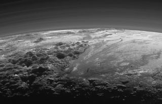 NASA’s New Horizons spacecraft looked back toward the sun 15 minutes after its closest approach to Pluto on July 14, 2015, capturing this near-sunset view of the dwarf planet’s icy mountains and flat ice plains. The image was taken from a distance of 11,000 miles (18,000 kilometers) from Pluto; the scene is 780 miles (1,250 km) wide.