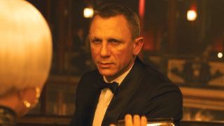 Daniel Craig sits casually awaiting the martini that's being poured at the bar in Skyfall.