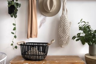 A entryway shelf with a black metal wire basket