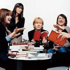 women around a table full of books