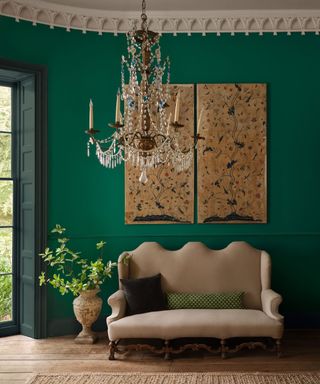 living room with dark green walls, high ceilings, beige formal couch and traditional decor with chandelier