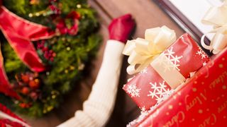 Woman knocking on door with Chrismas gifts