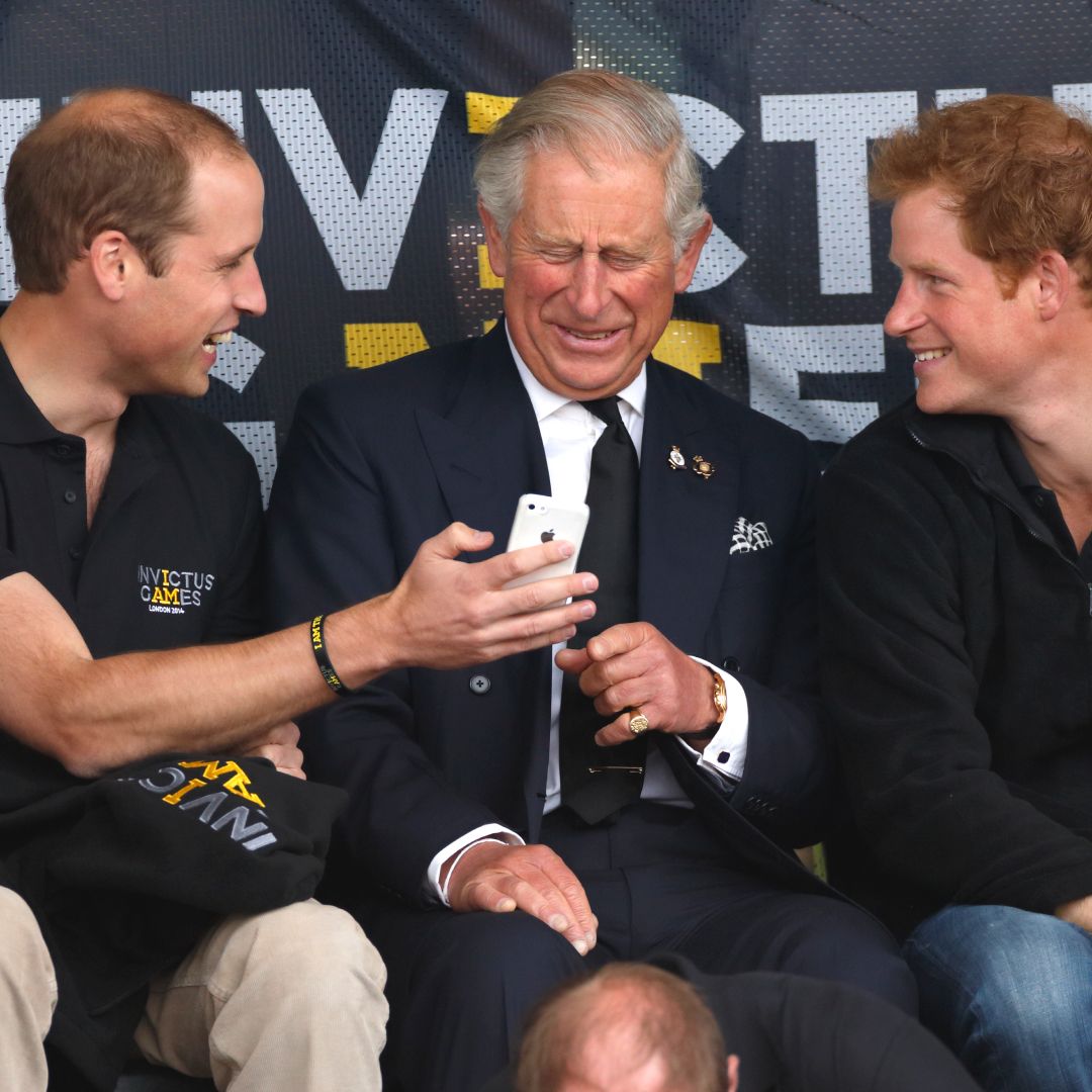 Prince William and Prince Harry looking at an iPhone