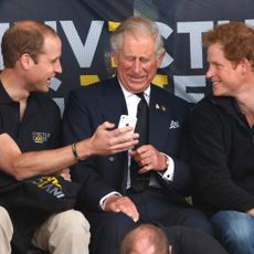 Prince William and Prince Harry looking at an iPhone