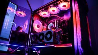 A liquid-cooled gaming PC with red RGB lighting.