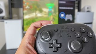 A person playing The Legend of Zelda Tears of the Kingdom with a Nintendo Switch 2 Pro Controller with the Switch 2's Quick Settings menu showing how you remap the GL/GR buttons visible on screen