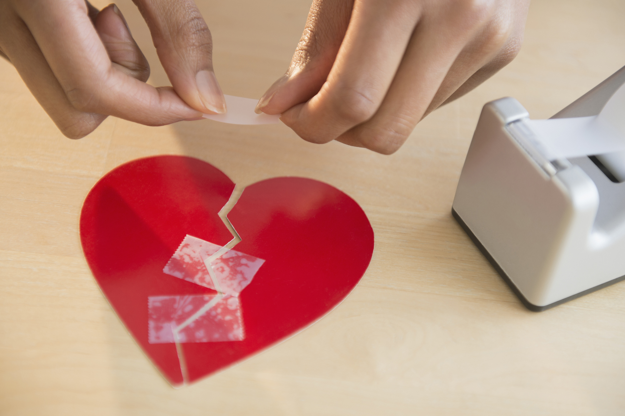 Woman taking broken paper heart