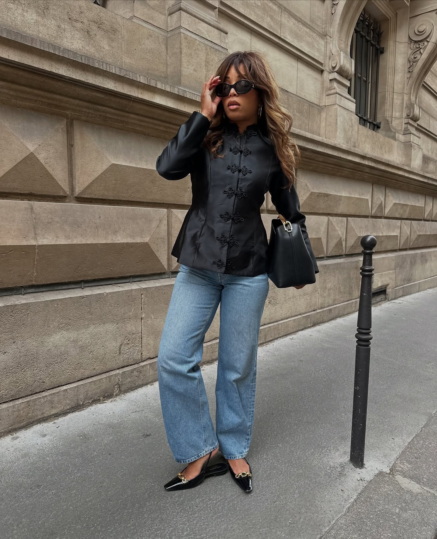Woman in blue jeans and black jacket.