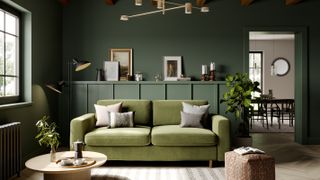 green living room with green sofa and wall panelling